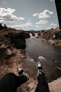 Low section of person on land against sky