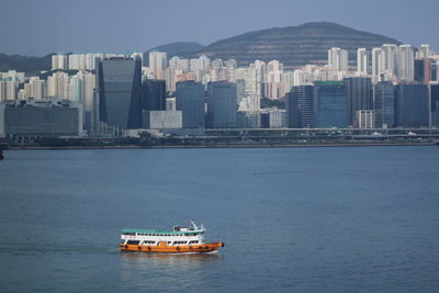 Ship in sea against buildings in city