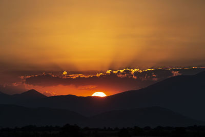 Scenic view of silhouette mountains against romantic sky at sunset