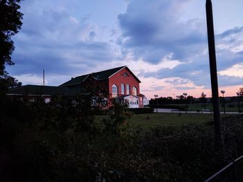 Houses on field against sky during sunset