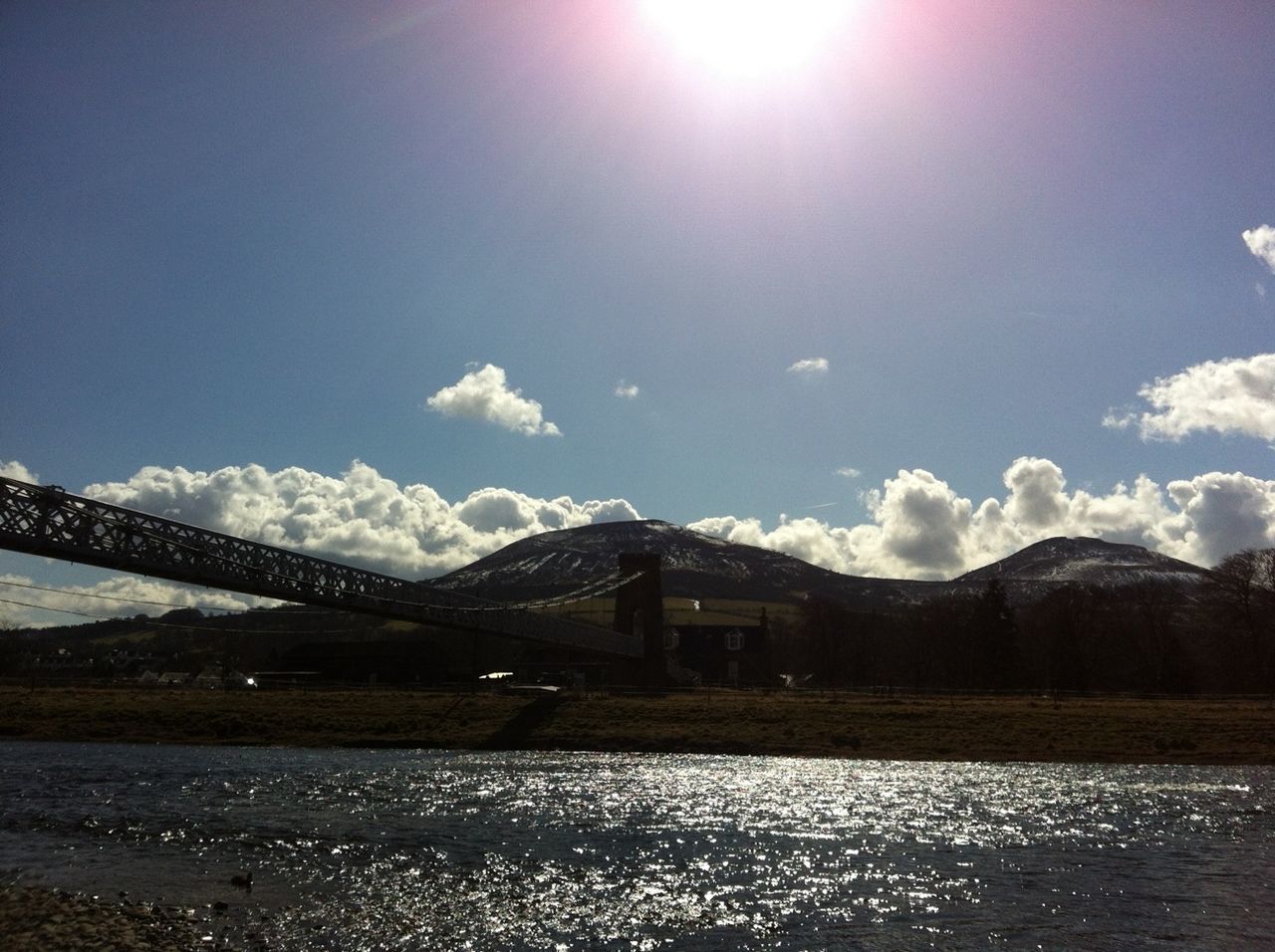 snow, mountain, winter, cold temperature, built structure, mountain range, architecture, sky, season, tranquil scene, tranquility, sunlight, nature, snowcapped mountain, sun, beauty in nature, weather, scenics, water, river