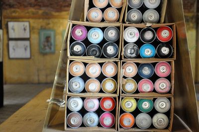 Close-up of colorful aerosol cans in box on table