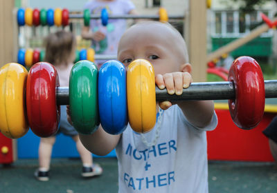 Close-up of boy holding multi colored umbrella