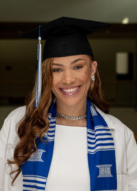 Portrait of smiling young woman wearing graduation gown