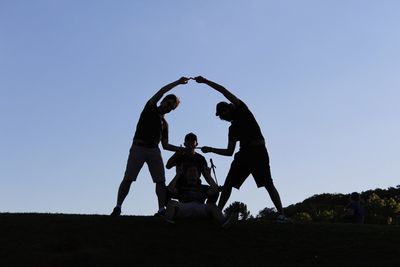 People standing on field against clear sky