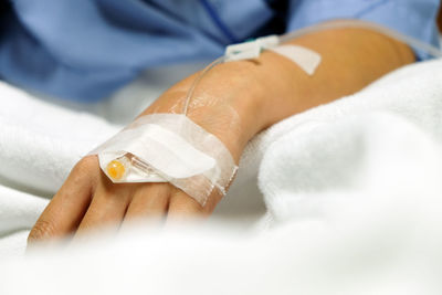 Close-up of woman hand with medical equipment on bed