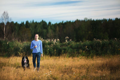 Man with dog walking on grass