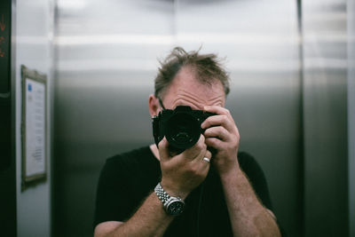 Close-up of man photographing with camera