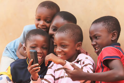 Portrait of smiling friends using mobile phone