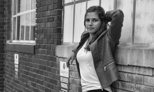 Portrait of teenage girl leaning against wall