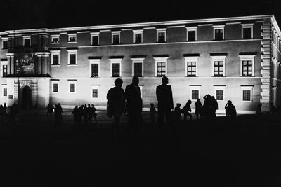 People walking in front of building at night