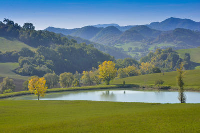 Scenic view of field by mountains against sky