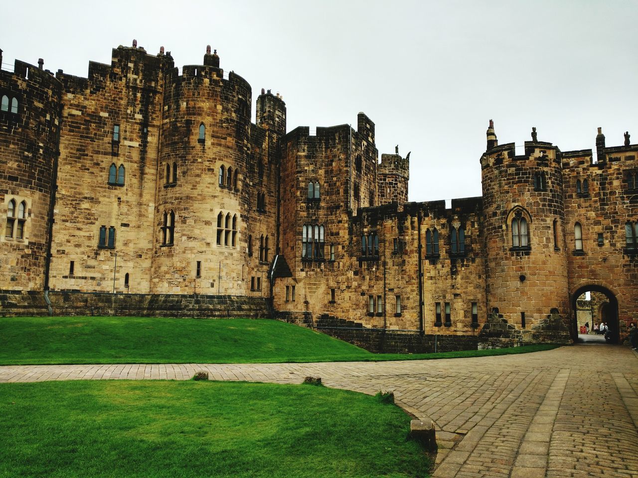 built structure, architecture, building exterior, residential building, clear sky, lawn, city, pathway, walkway, old town, outdoors, history, day, facade, medieval, apartment, fortified wall, sky, in front of, footpath, residential district