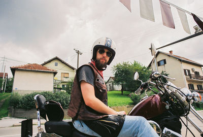 Portrait of smiling young man sitting on motorcycle
