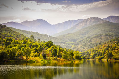 Scenic view of lake and mountains against sky