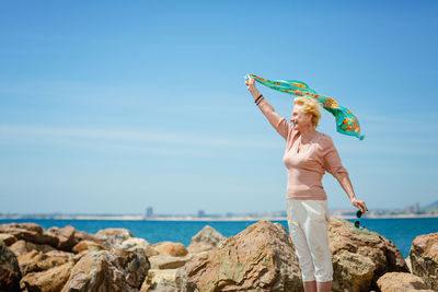 Happy mature woman smiling and having fun at beach