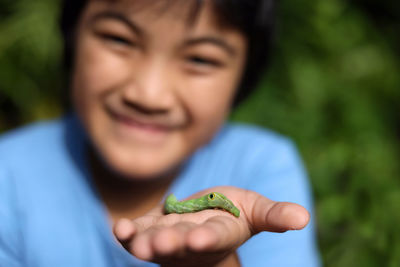 Portrait of smiling boy holding leaf