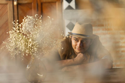 A charming man in a vintage brown retro atmosphere a sitting position and a happy smile