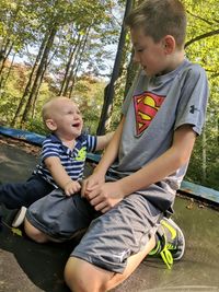 Happy siblings playing on tree