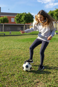 Full length of woman with ball on soccer field