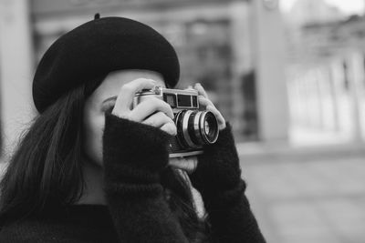 Young woman photographing with camera