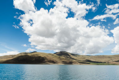 Scenic view of calm lake against cloudy sky