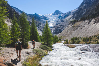 Rear view of people walking on mountain road