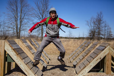 A man with a backpack leaps across ramps in obstacle course outside