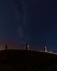 Stone heads on the hill at summer night with visible milky way galaxy