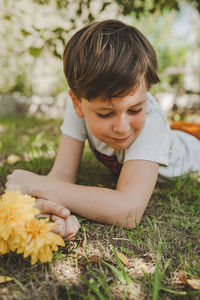 Cute boy with flowers on plants