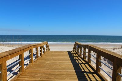 Scenic view of beach against clear blue sky