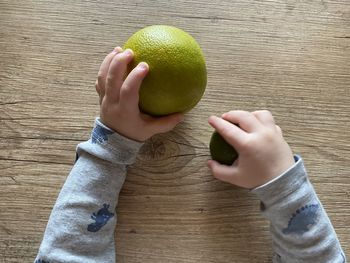 High angle view of hand holding fruit on table