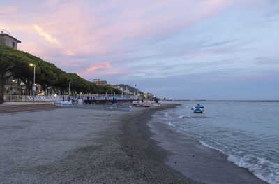 Scenic view of beach against sky at sunset