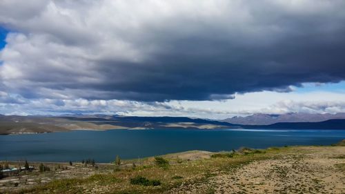 Scenic view of calm lake against cloudy sky