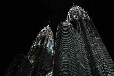 Low angle view of illuminated petronas tower against sky at night