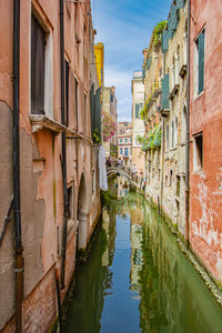 Canal amidst buildings against sky