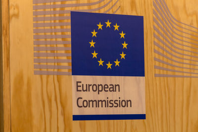 Close-up of european commission sign on wooden wall