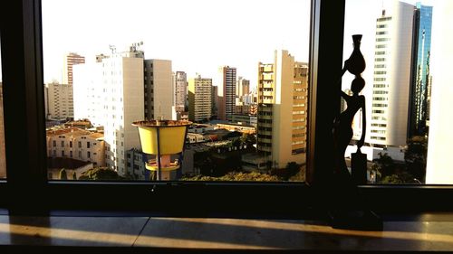 Buildings against sky seen through glass window