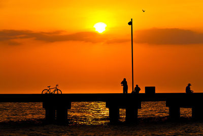 Walking on bridge against sunset