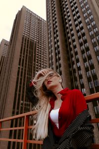 Low angle view of woman against buildings in city