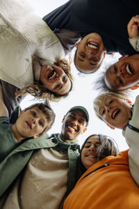 Directly below shot of kids huddling with counselors against sky