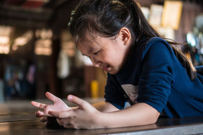 Close-up of man using smart phone on table