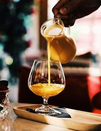 Close-up of hand pouring juice on table 