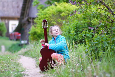 Cute girl playing guitar outdoors