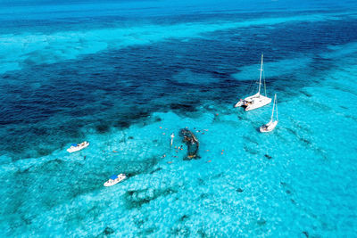 People snorkelling around the ship wreck near bahamas in the caribbean sea.