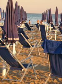 Chairs on beach against sky