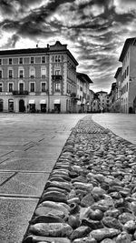 Surface level of walkway against cloudy sky