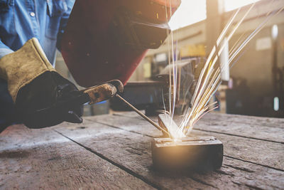 Close-up of hands welding metal in workshop