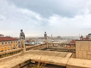 Buildings in city against cloudy sky