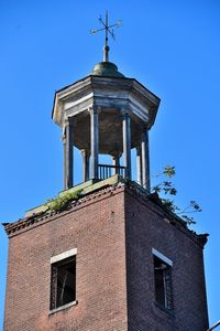 Low angle view of old building against clear blue sky